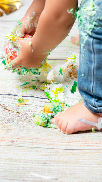 istock Babies hands smashing birthday cake during first celebration 2241271055