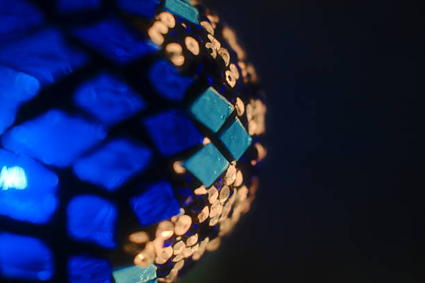 Decorative lamp shade with warm light next to a bookshelf. High quality photo