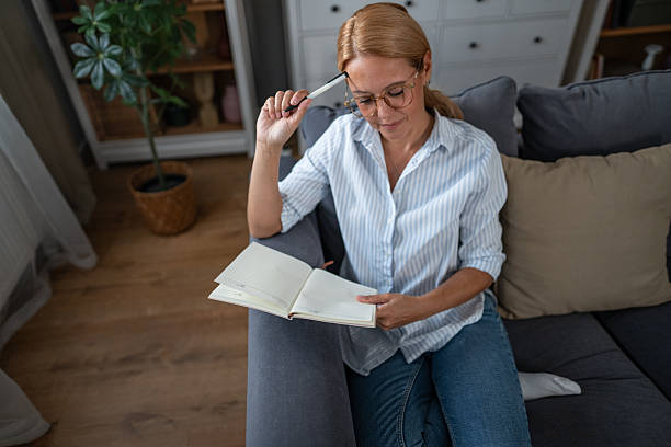 istock Woman thinking, planning, and writing in notebook at home 2241272782