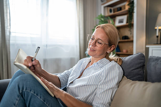 istock Woman journaling on sofa, relaxing at home, mindful living 2241272885