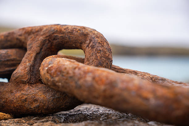 Close-up view of old, weathered iron chain links severely rusted, symbolizing strength, connection, or decay
