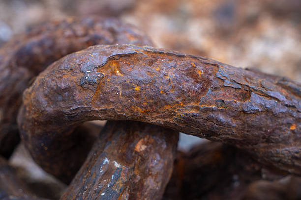 Close up view of heavy rusty metal chain links, demonstrating extreme decay, weathering, and endurance over time