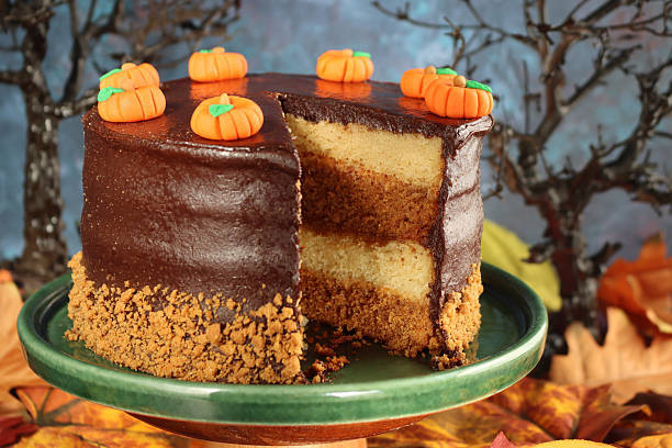 istock Image of festive halloween cake, chocolate sponge layers, caramel icing, and cream, decorated with pumpkins and autumn leaves 2241283220