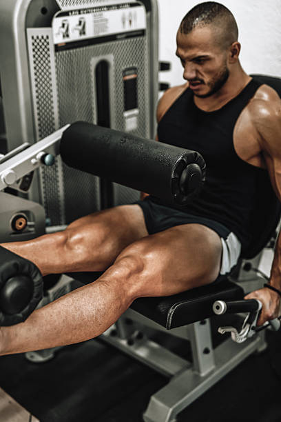 istock Strong Man Using Leg Extension Machine in Indoor Gym During Intense Leg Workout 2241283499