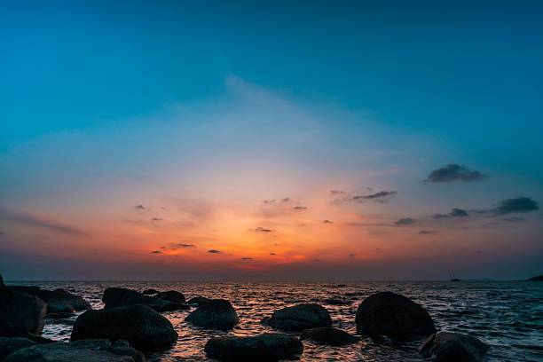 Beautiful tropical beach with a colorful sunset above the calm ocean. Golden light reflects on the waves, creating a peaceful and romantic atmosphere. Perfect nature scene symbolizing relaxation, summer travel, and exotic island paradise.
