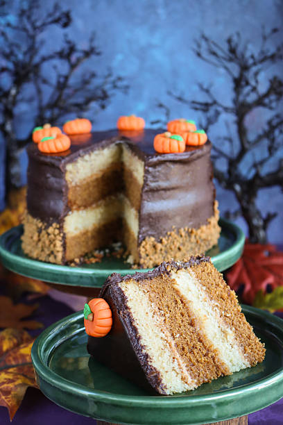 istock Image of festive halloween cake with chocolate sponge layers, caramel icing, and cream, decorated, pumpkins and autumn leaves 2241285875