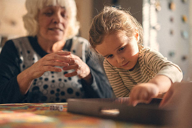 istock Family Connection. Multigenerational Family Plays Board Game 2241285983