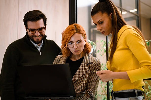 istock Team collaboration in a modern office setting while discussing project details on a laptop during work hours 2241286702