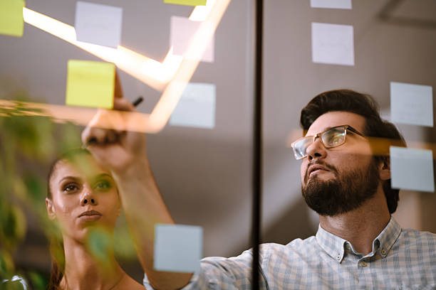 istock Team members discussing ideas on sticky notes during a brainstorming session in a modern office environment in the afternoon 2241286856