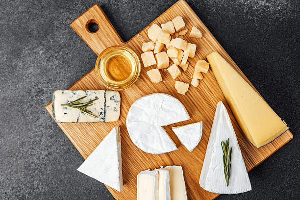 istock Cheese platter displayed on wooden board with honey and herbs 2241287074