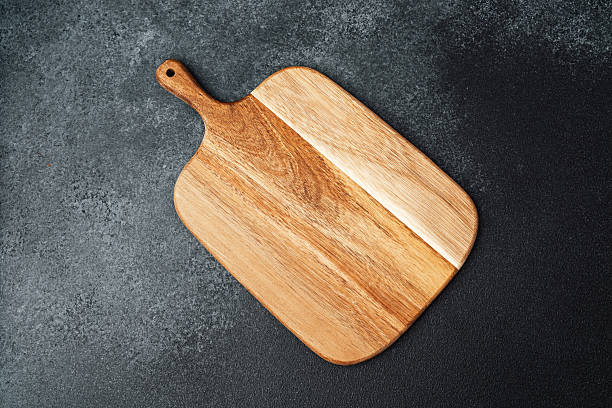 istock Crafted wooden cutting board displayed on dark textured surface 2241287103