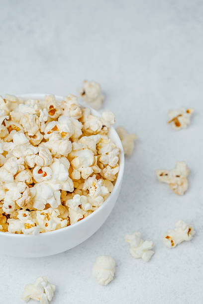 istock Bowl of freshly popped popcorn on a white surface ready for snacking 2241287154