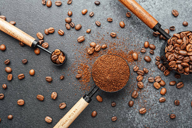istock Ground coffee and beans in measuring scoops on dark background 2241287262
