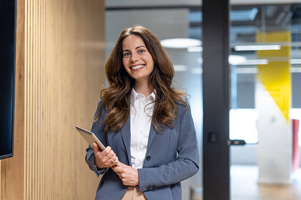 istock Smiling businesswoman holding digital tablet in modern office 2241288075