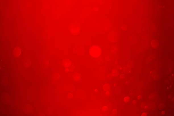 Red christmas festive bokeh background with glowing light.