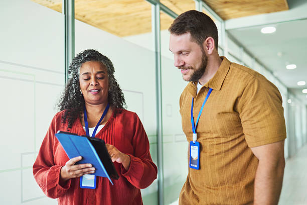istock Diverse Coworkers Reviewing Digital Data in Office Corridor 2241294276