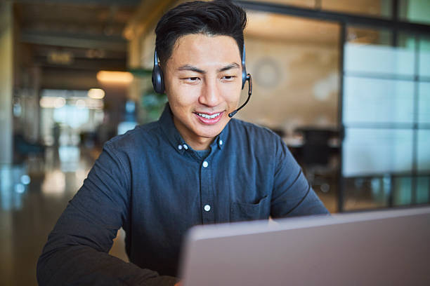 istock Smiling Asian Customer Service Representative on Headset and Laptop 2241294347