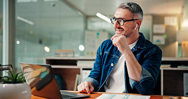 istock Online reading, graphs and man with laptop, night and documents with internet, investment and email. Mature person, evening and employee in office, pc and charts with trading, report and earphones 2241294469