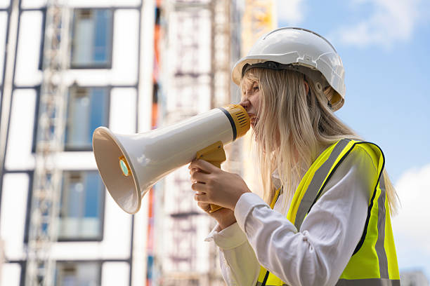 istock Builder woman girl screaming in megaphone loudspeacker on construction site to make announcement 2241317031