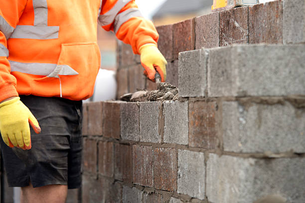 istock Close-up of Construction worker laying concrete blocks on building site 2241317396