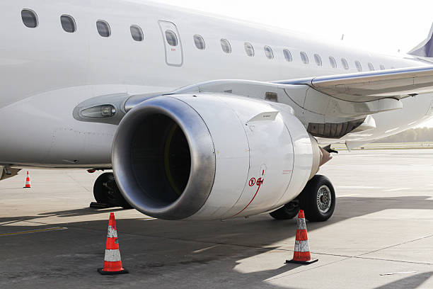 Airplane engine and wing closeup. Jet parked on runway. Modern aircraft ready for boarding. Aviation travel industry concept.