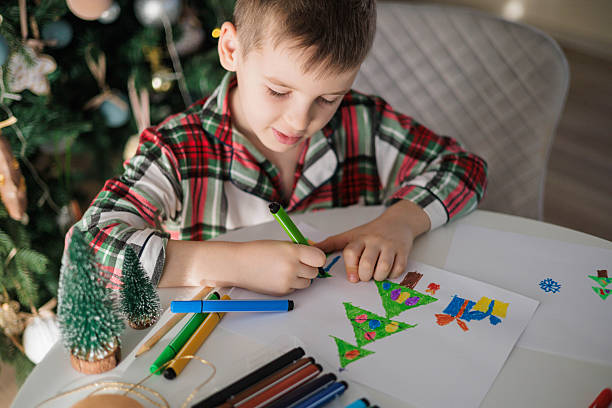 istock Child Drawing Christmas Tree with Markers at Holiday Table, Festive Creative Activity 2241320773