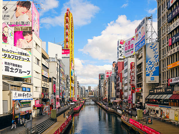 Osaka Japan’s Dotonbori shopping street and canal on a sunny afternoon.