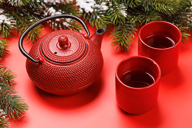 istock Christmas tea setting with teapot, cups, and fir tree branches 2241322464