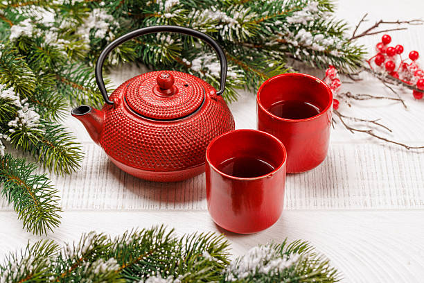 istock Christmas tea setting with teapot, cups, and fir tree branches 2241322487