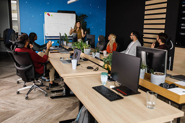 istock Team presentation in a modern office meeting room with a diverse group and whiteboard 2241324383