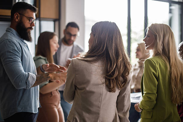 istock Group of professionals in a busy office discussing ideas and networking in a modern setting 2241325438