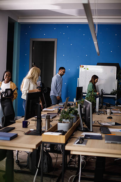 istock Team of professionals in a collaborative modern office with a blue starry wall and whiteboard 2241325449