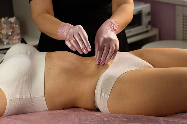 istock Aesthetician performs abdominal massage wearing pink protective gloves. 2241326172