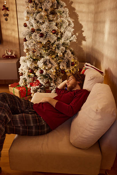istock Tired man taking a nap during New Year at home. 2241326736