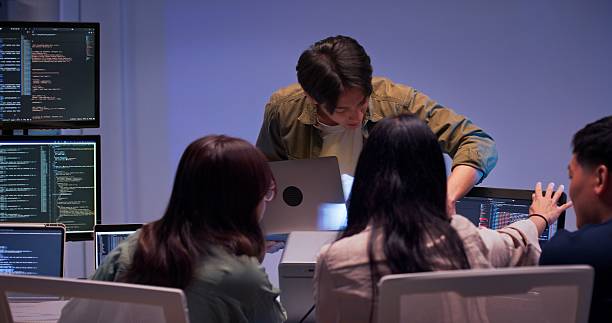 istock Asian tech team collaborates and reviews code together at night in office lab 2241326760