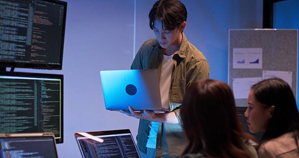 istock Asian tech team collaborates and reviews code together at night in office lab 2241326783