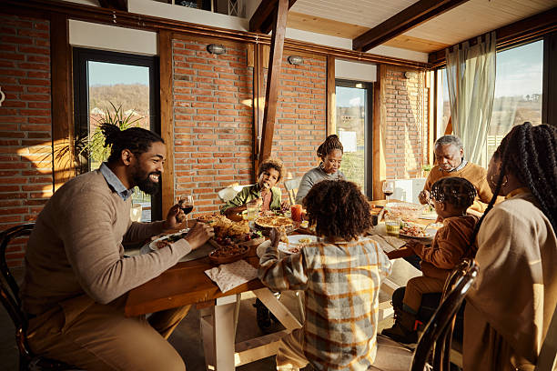 istock Black multi-generation family having a meal at dining table. 2241329156