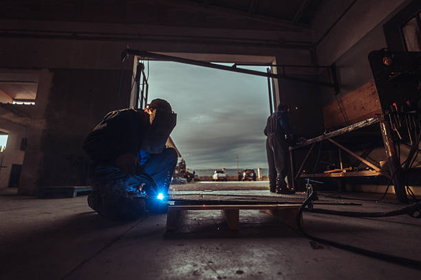 Photo of a welder connecting iron to make a fence.