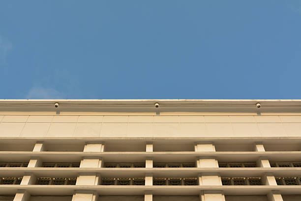 Stock image of a Dutch colonial building featuring elegant classic windows illuminated by warm afternoon sunlight under a clear blue sky. The image highlights the architectural charm and historical aesthetic of European-style colonial heritage found in Southeast Asia. Perfect for themes related to history, architecture, tourism, or cultural heritage preservation.