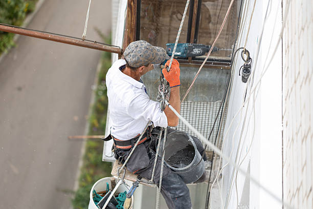 istock Construction worker insulating the exterior wall of a building with polystyrene panels at height. 2241337446