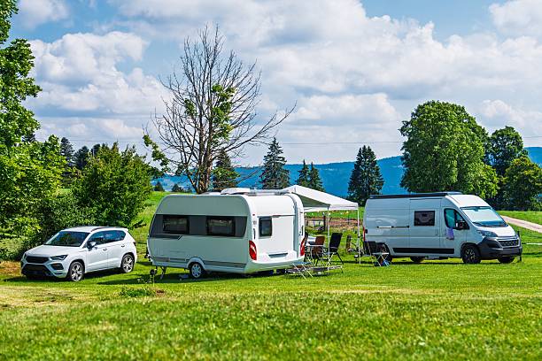 istock Camping Adventure Caravan, Car, and Camper Van on Green Meadow under Blue Sky with Clouds 2241341494