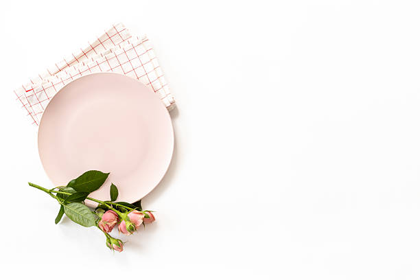 istock Stylish table setting with empty plate and napkin - flowers decorated on white background, top view, flat lay 2241341892