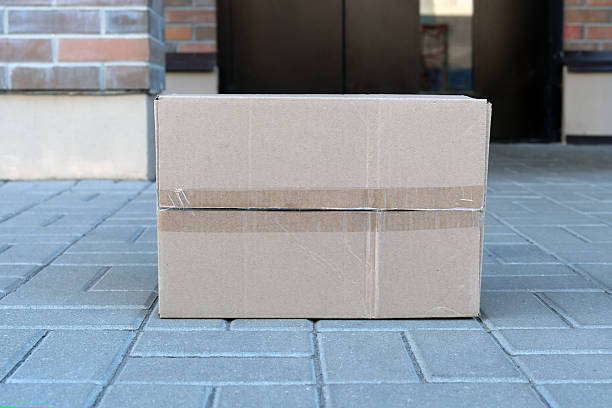 istock Cardboard box package delivered at front door doorstep 2241342094