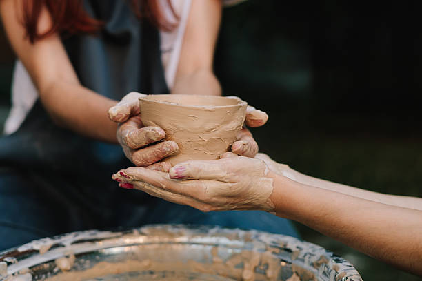 istock Handmade clay bowl is held after removal from the wheel. Ceramic pot reflects artistry, patience, and cultural tradition. Finished clay pot in hands. 2241344132
