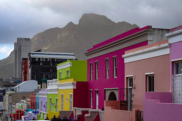 Brightly painted houses line a street in Bo-Kaap, Cape Town, South Africa. The historic neighborhood is famous for its vibrant colors and rich cultural heritage
