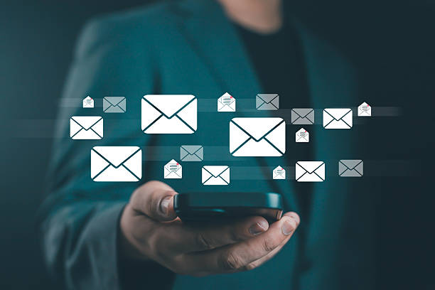 istock Businessman using smartphone with floating email icons, concept of online communication, digital marketing, email notification, technology network, and modern business connection. 2241346136