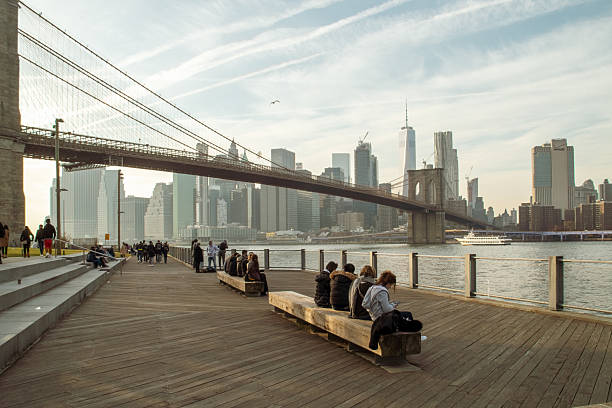 New York, USA. 11 11 2019. An autumn evening with people strolling overlooking Manhattan's financial district and the Brooklyn Bridge.