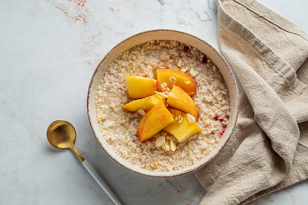 istock Oatmeal with peaches and nuts  in a bowl on a marble background with honey 2241347533