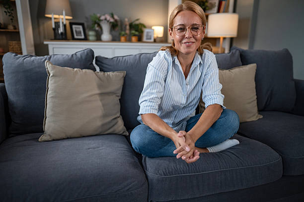 istock Woman with glasses smiling while relaxing on couch 2241347653