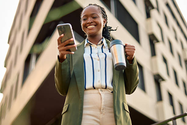 istock Businesswoman checking smartphone and smiling on coffee break 2241349109